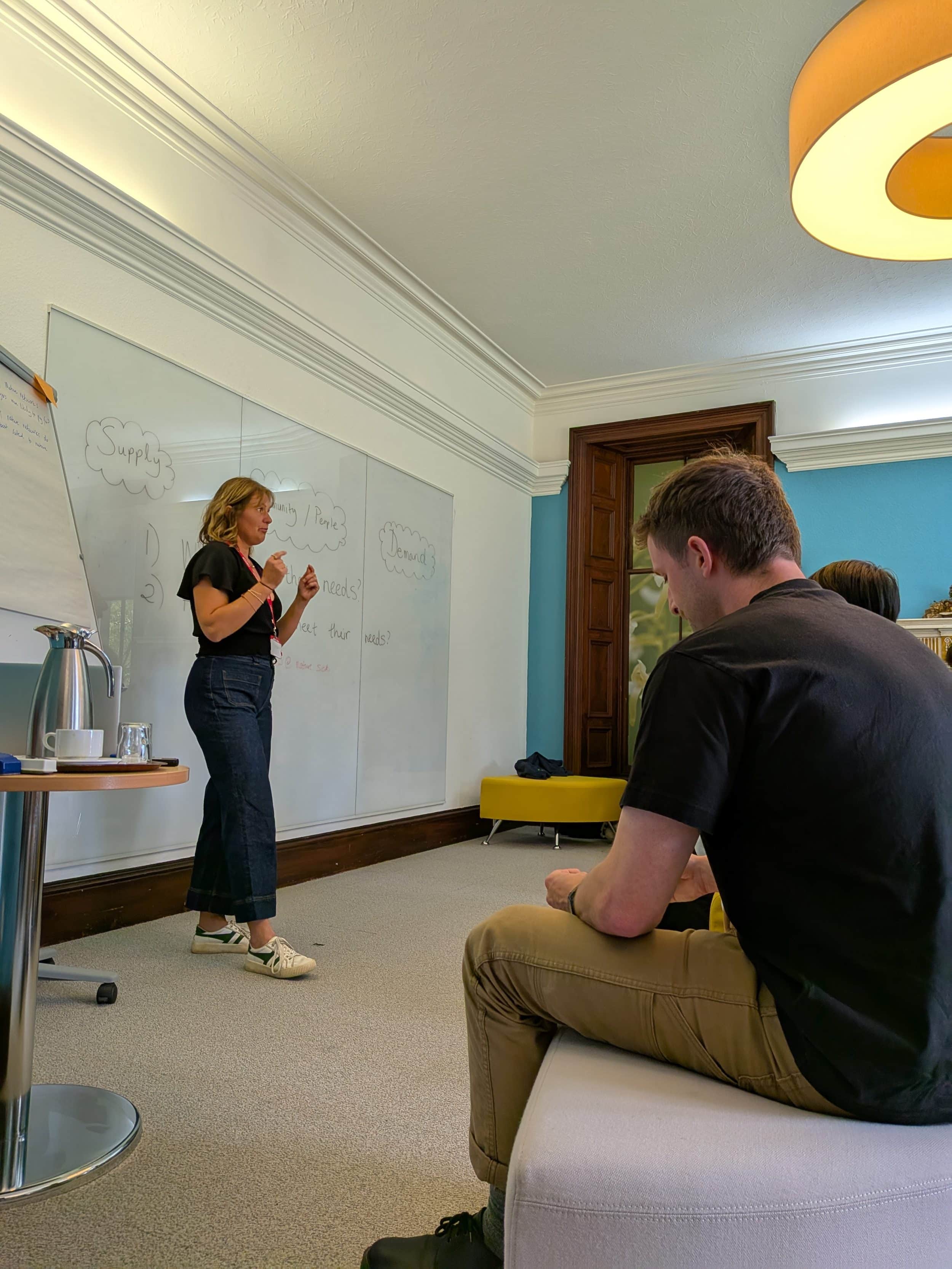 a woman presenting in front of a whiteboard